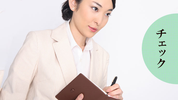 観察しながらメモ帳に書き込む女性