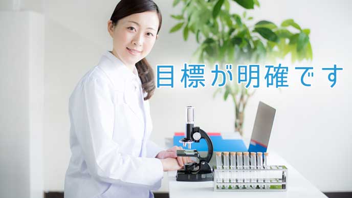 大学の研究で顕微鏡を使っている女性