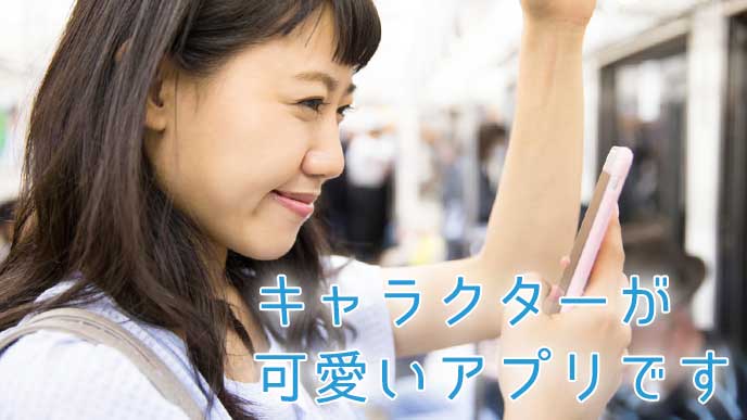 通勤中の電車内でスマホを見ながらニッコリ微笑んでいる女性