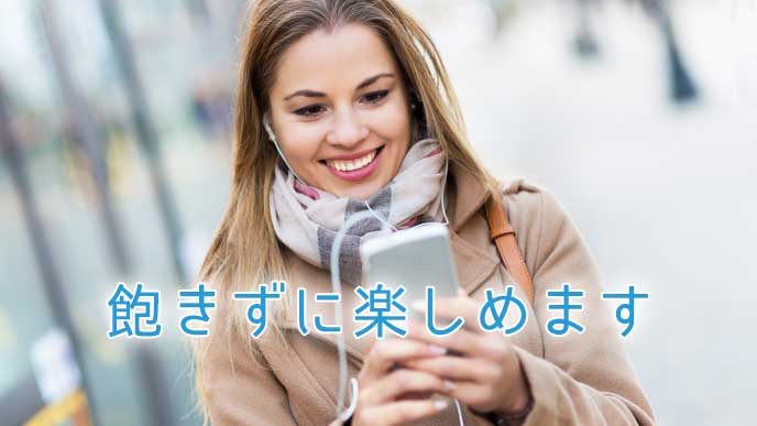 バス停でスマホを見ながら嬉しそうな表情をしている女性