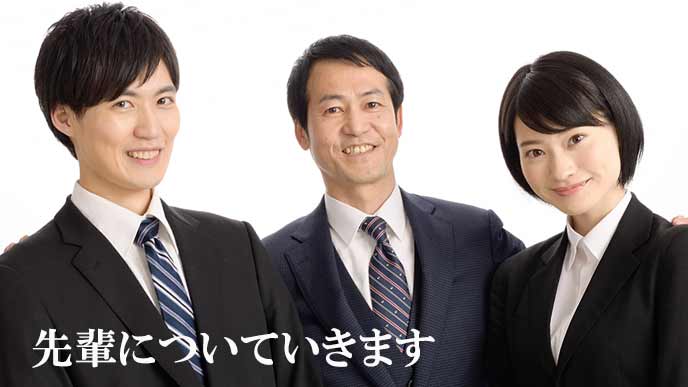 先輩社員の両脇に立つ若手社員