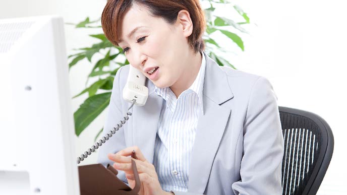 電話を受けながらメモする女性