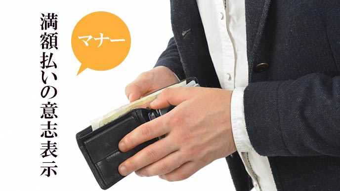 財布からお札を出そうとする男性