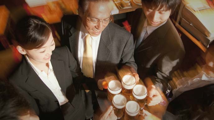 ジョッキを持って乾杯するサラリーマンたち
