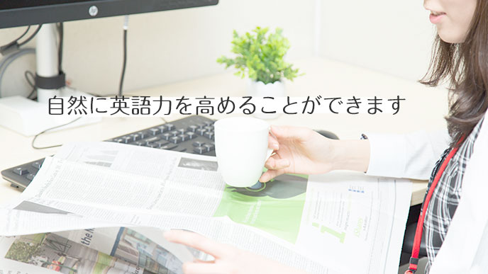 コーヒーの飲みながら英語の新聞を読んでいる女性