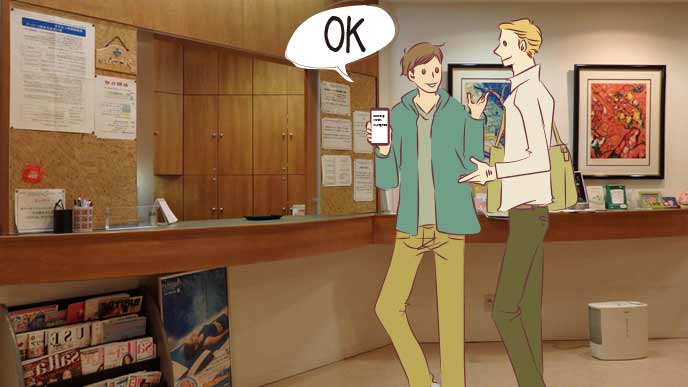 宿泊施設で外人客にスマホの表示を見せる職員