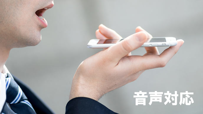 スマホに向かって音声翻訳をする会社員