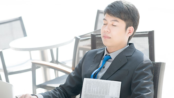 机で昼寝をする男性