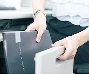 引き出しからファイルを出す女性の手