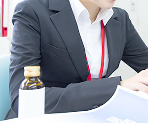 女性社員と栄養ドリンク
