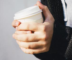 ホットコーヒーを両手で持つ