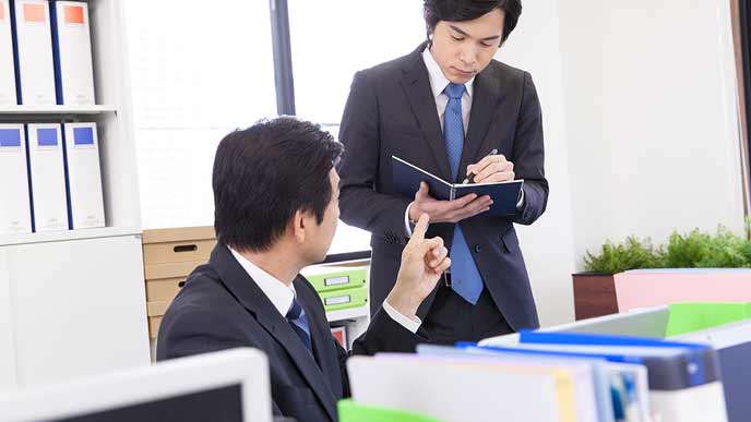 上司の指示をメモする社員