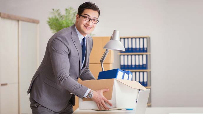 さわやかな笑顔で身の回りを整理する男性