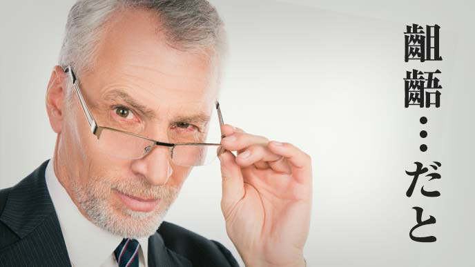 部下に齟齬と言われムッとした表情の眼鏡をかけた年配の男性