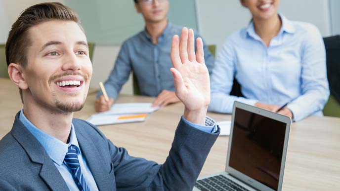 会議中明るく挙手する男性