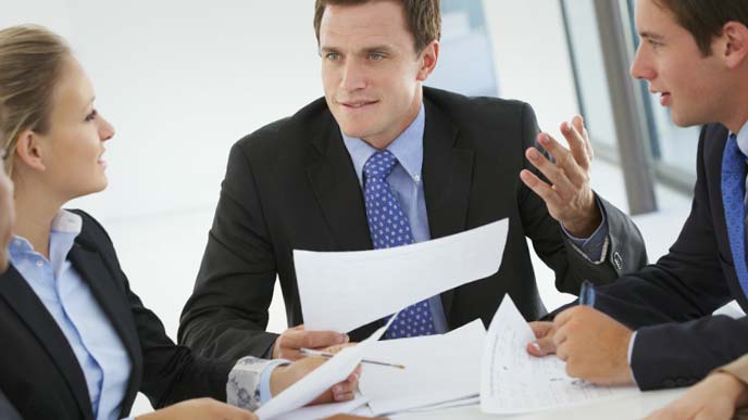 資料を手に熱心なディスカッションを続ける男性