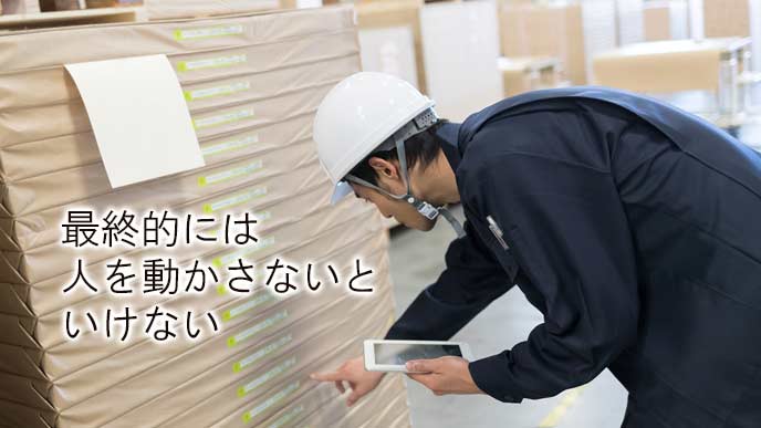 積み上げられた商品をチェックする社員