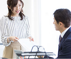 上司に書類を提出する部下