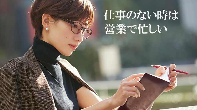 外でスケジュール帳をチェックする女性