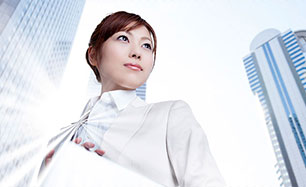 女性社員と会社のビル