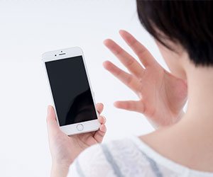 スマホを見て驚く女の人