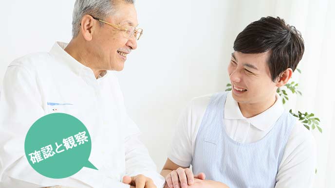 利用者の世話をする男性スタッフ