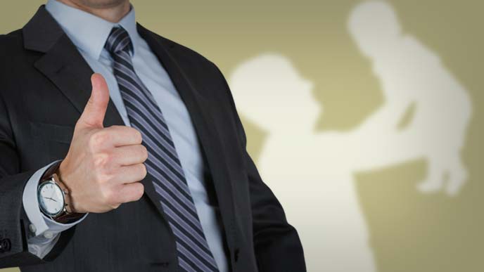 サムズアップするスーツ姿の男性