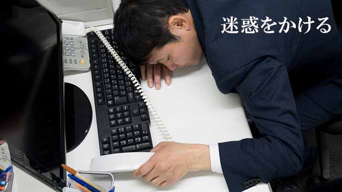 仕事中にデスクに倒れる会社員