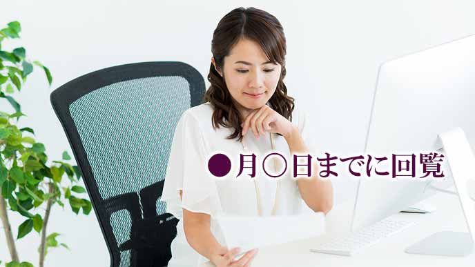 回覧文書を読む女性社員