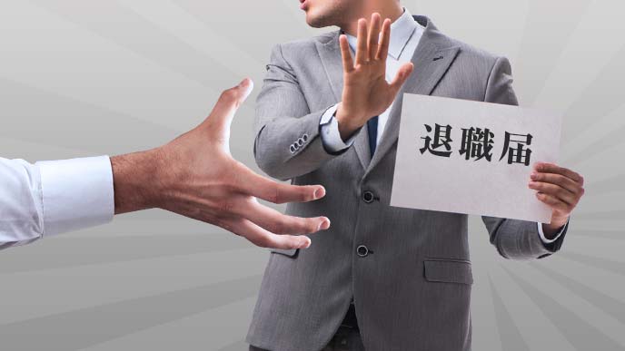 手にした退職届に伸ばされる誰かの手と、拒否する男性