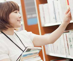 本を書棚に戻す司書