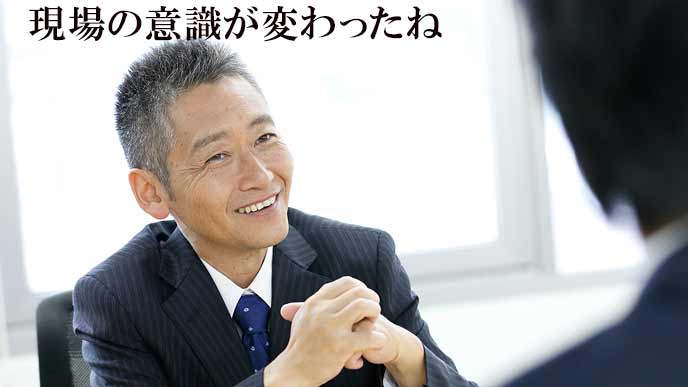 笑顔の役員と報告する社員