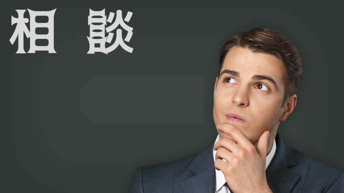 下あごに手をかけ首を傾げ斜め上を見上げる男性