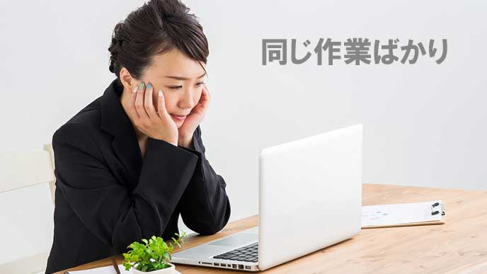 同じ作業に飽きて頬杖つきながらPCを見つめる女性社員