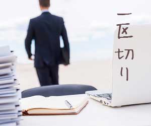 書類の山からいったん離れるビジネスマン