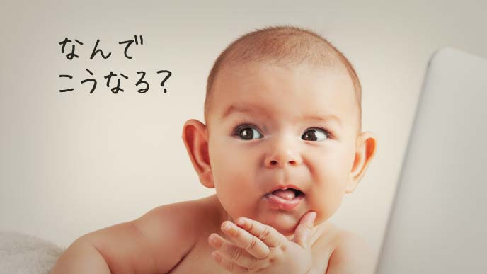 パソコンの前で原因に思いを巡らす赤ちゃん