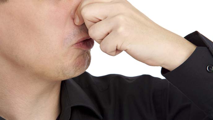 鼻をつまんで息を止める男性