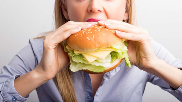 サンドイッチに食らいつく女性