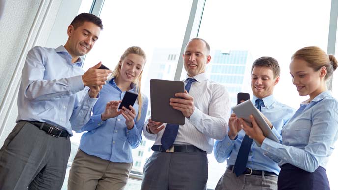 社内SNSを使う数人の男女社員