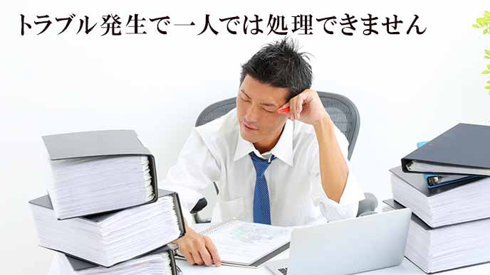 机の上の大量のファイルに辟易する会社員