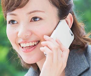 お礼の電話をする女性