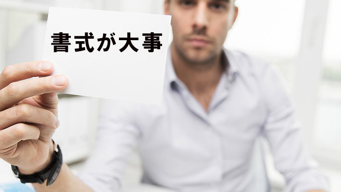 書式が大事と書面を差し出す男性