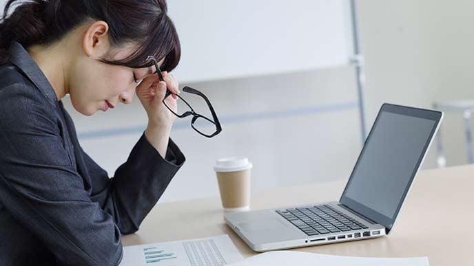 職場のデスクで悩む女性