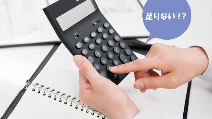 電卓で給料の計算をする女性社員