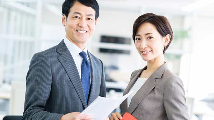 書類を見ながら会話する会社員