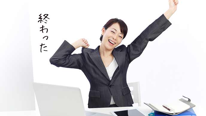 仕事を終えて背伸びする女性社員